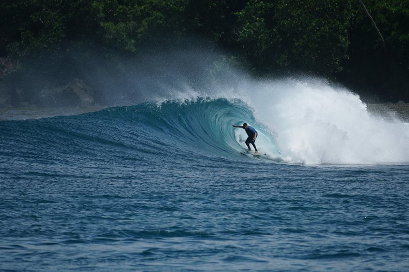 Treasure Island: A surfer riding a wave in the Banyak Islands