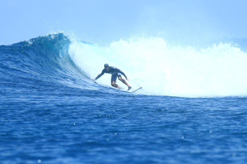 Gunturs: A surfer riding a wave in the Banyak Islands
