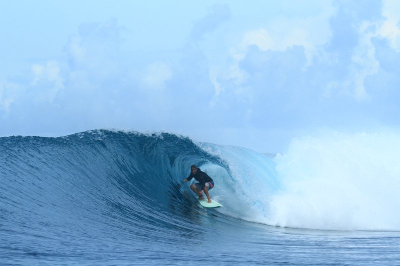 Lizard Nest: A surfer riding a wave in the Banyak Islands