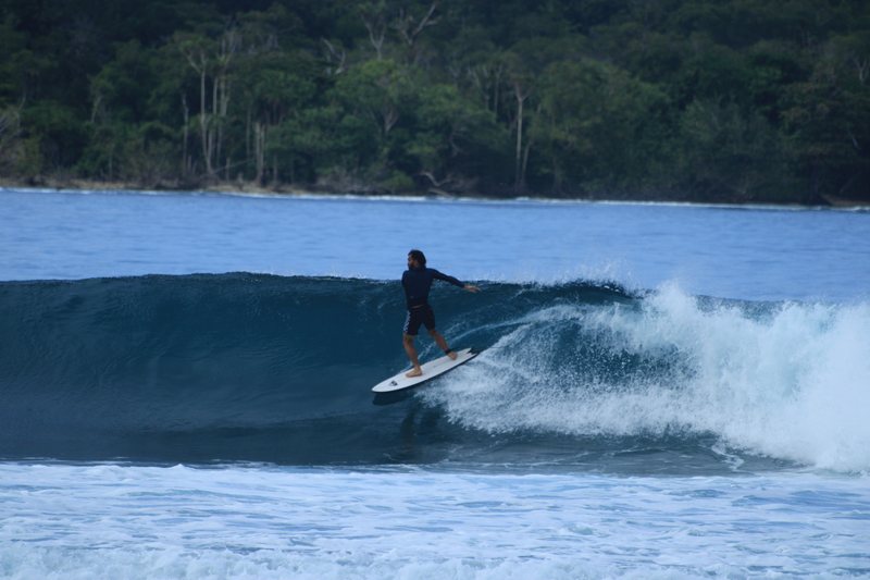 Gunturs: A surfer riding a wave in the Banyak Islands