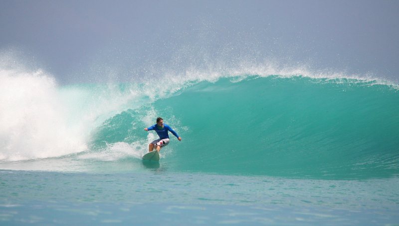 Dindos: A surfer riding a wave in the Banyak Islands