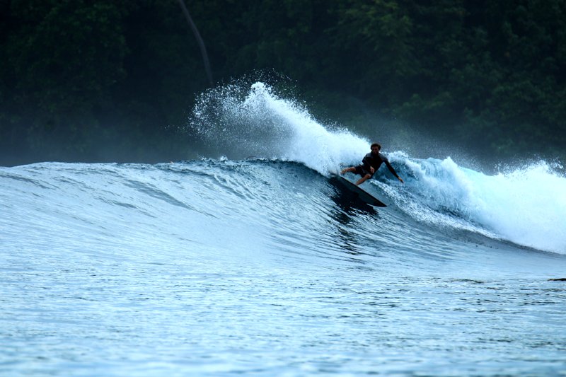 Treasure Island: A surfer on a breaking wave in the Banyak Islands