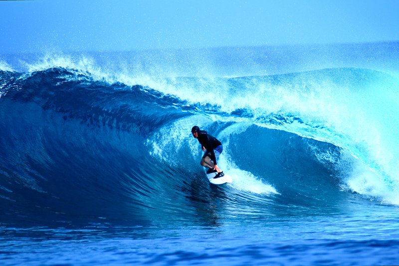 A surfer inside a blue barrel at Treasure Island