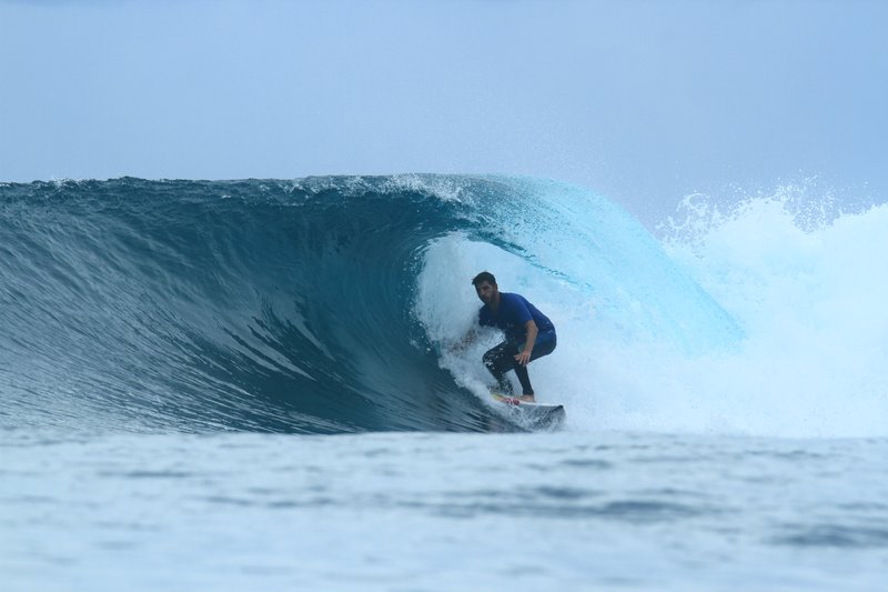 Shortys: A surfer on a breaking wave in the Banyak Islands