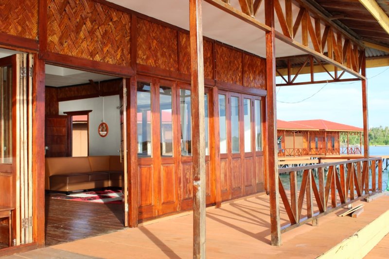 The wooden walkway and open villa doors