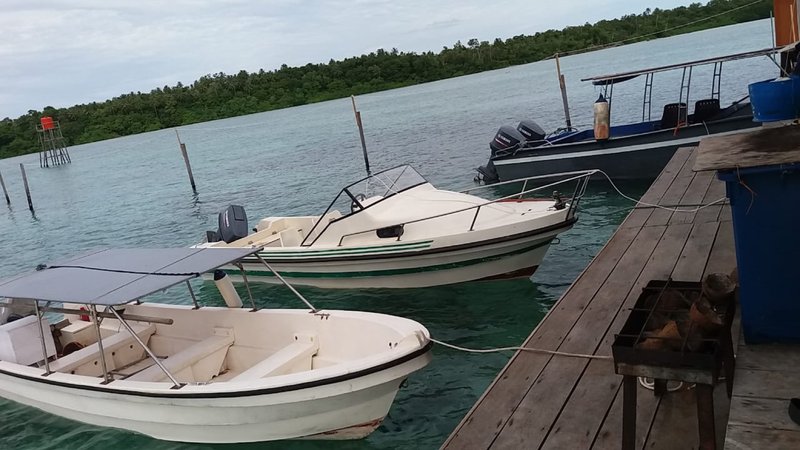 Three surf boats moored at the dock beside the villas