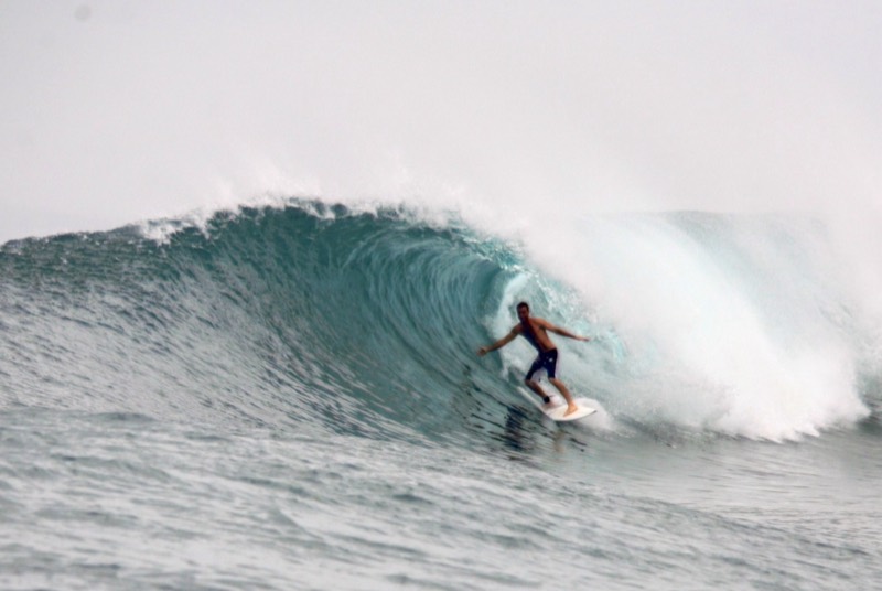 A surfer riding through the barrel at Camel Backs